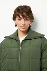 Campera marrón capitoneada de manga larga con cuello alto de tela, cierre frontal y bolsillos laterales con cierre.