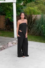 Pantalón de corte amplio y tiro medio, confeccionado en tela crepe color beige, con diseño fluido y holgado.