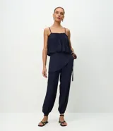 Pantalón modelo aladim confeccionado en jacquard de viscosa, con diseño floral en relieve, cintura elástica y superposición asimétrica en el delantero que forma un canesú redondeado.