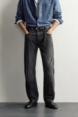 Jeans straight fit de corte recto y tiro medio, confeccionados en denim de algodón rígido con efecto lavado en color negro, de la colección especial Aaron Levine x Zara. Presentan diseño clásico de cinco bolsillos y cierre frontal con botonadura.