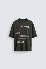 Camiseta de algodón con corte relajado, cuello redondo y manga corta. Presenta estampados gráficos a contraste en el frente con inscripciones tipo señalética.