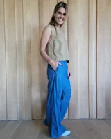 Pantalón de algodón color arena, de corte recto y holgado, con cintura elástica y detalle de costuras horizontales decorativas en la parte inferior de las piernas.