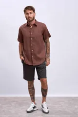 Camisa de manga corta color marrón, con cuello clásico y botones blancos.