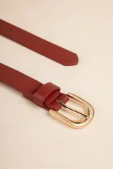 Cinturón color beige de cuero sintético con hebilla dorada texturizada.