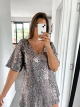 Túnica corta de lentejuelas color plata oscuro, con escote en V y mangas cortas holgadas.