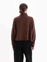 Polera de tejido de punto color marrón, con cuello alto y diseño holgado de corte oversize.