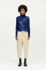 Pantalón de gabardina color beige, de diseño relajado con pierna bombé, recorte en las piernas, cuatro bolsillos y cierre con ganchos sastreros y botón interno.