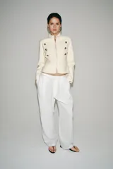 Chaqueta estilo militar ZW Collection confeccionada en hilatura con mezcla de algodón, color crudo, con cuello subido, manga larga, falsos bolsillos de vivo y cierre frontal con ganchos metálicos y botones decorativos dorados.