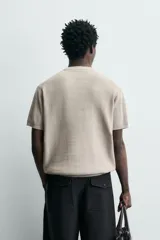 Camiseta de punto de algodón con textura perlada, corte regular fit, cuello redondo y manga corta con terminaciones en rib.