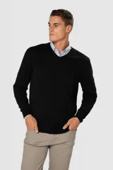 Suéter de tejido fino color azul marino, con cuello en V y manga larga. Presenta un pequeño logo bordado en el pecho.