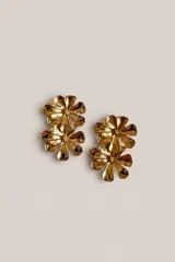 Aros colgantes dorados con diseño de dos flores superpuestas de acabado brillante y orgánico.