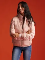 Campera puffer reversible color beige, marca Michael Kors. Un lado es liso y el otro estampado. Tiene cierre metálico central, bolsillos delanteros y bolsa autoportante.