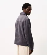 Campera Marfinno de corte regular confeccionada en poliéster con tacto aterciopelado, diseño de raya diplomática, cuello estructurado, bolsillos laterales y cierre frontal con cremallera.