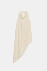 Top color crema confeccionado en viscosa, con cuello halter drapeado, espalda descubierta y bajo asimétrico. Cierre en el cuello con botón.