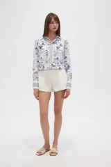 Short de viscosa color beige, con pinzas frontales, bolsillos laterales y cierre de botón.