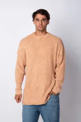 Buzo color durazno de tela waffle de algodón con teñido acid wash y corte oversize.