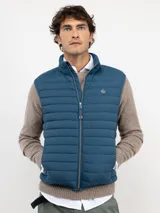 Chaleco acolchado de hombre confeccionado en nylon reciclado, con cierre frontal de cremallera, sisas elásticas y bolsillos laterales con cierre.