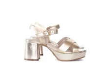 Sandalias de plataforma con taco cuadrado, confeccionadas en cuero metalizado color oro claro. Presentan tiras cruzadas en el empeine y cierre con hebilla ajustable en el tobillo.