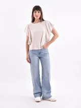 Remera blanca de algodón con cuello redondo y mangas cortas con volados fruncidos en los hombros.