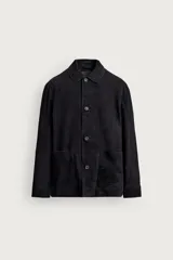 Sobrecamisa relaxed fit de piel con acabado en ante color negro, con cuello solapa, manga larga con puño abotonado, bolsillos de parche en la cadera y cierre frontal de botones.