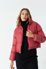Campera puffer corta color ladrillo, con cuello alto y cierre frontal.