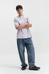 Remera oversize de manga corta color lila, con escote redondo y estampado frontal que dice "STAY ORIGINAL FOREVER".