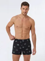 Bóxer negro de algodón liviano, con cintura elastizada y estampado integral de pequeños tractores verdes.