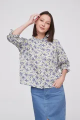 Blusa de viscosa con estampado floral, cuello a la base con detalle de volados, cierre frontal con botones y mangas tres cuartos abullonadas con puños elásticos.