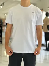 Remera clásica lisa de color blanco, manga corta, cuello redondo y un pequeño logo impreso en el pecho.