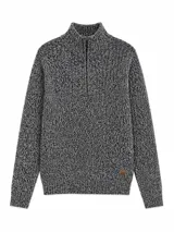 Buzo de tejido de punto grueso con cuello alto y cierre frontal parcial. Presenta un diseño jaspeado en tonos negro y blanco, con puños y ruedo acanalados y un pequeño parche decorativo en la parte inferior.