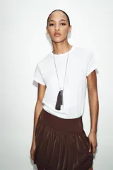 Remera blanca de algodón, de corte regular fit, cuello redondo y manga corta con acabados sin costuras.