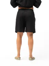 Short de lino con cintura elástica y cordón ajustable. Cuenta con dos bolsillos laterales y un bolsillo trasero, ofreciendo un ajuste cómodo y versátil.
