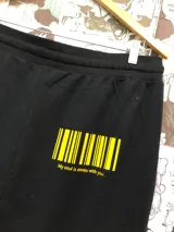 Short negro con cordón ajustable en la cintura y estampado de dos personajes de anime besándose.