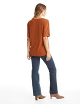 Blusa de silueta fluida con escote en V, manga japonesa corta y costura central vertical en el frente. Confeccionada en tejido de punto con acabado mate, presenta un diseño con largo asimétrico, siendo más larga en la espalda.