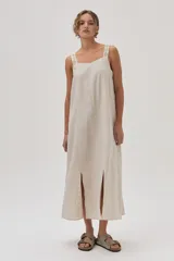 Vestido largo color beige de lino con tiras bordadas.