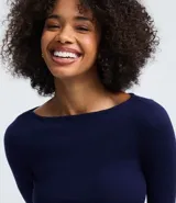 Suéter de punto ajustado con escote canoa y mangas largas. Presenta una superficie lisa y acabado clean, confeccionado en una mezcla de viscosa, poliéster y poliamida.