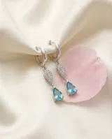 Caravanas colgantes de plata 925 con diseño de doble gota, una superior con pavé de circonias blancas y una inferior con una circonia central color celeste.