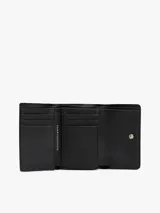 Billetera Tommy Hilfiger negra, plegable en tres partes, con sutil acabado granulado, cinta con el logo en la solapa, cierre a presión, compartimento interior para billetes, múltiples ranuras interiores para tarjetas y logo metalizado en la parte delantera.