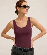 Musculosa básica de poliamida con escote en U y breteles anchos. Diseño liso, entallado y versátil.