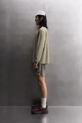 Camiseta de entrenamiento regular fit color gris oscuro, confeccionada en tejido técnico ligero y elástico con estructura. Cuenta con cuello redondo, manga larga y logo estampado en el bajo.