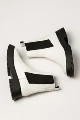 Bota Chelsea color verde militar de cuero, con elásticos laterales negros, tirador trasero y suela track negra.