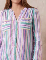 Blusa de lino estampada a rayas verticales en tonos blanco, verde, violeta, amarillo y rosa. Cuello a la base con escote en V y abertura central con botones. Delantera con bolsillos de parche. Mangas largas regulables con presilla y botón.