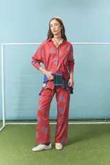 Camisa de algodón color rojo con estampado de soles en color azul, de corte oversize, cuello camisero y mangas largas.