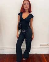 Pantalón negro de corte ajustado con cintura baja y hebilla plateada.