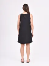 Vestido negro sin mangas, de corte recto y largo por encima de la rodilla.