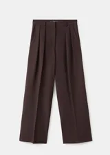 Pantalón de tiro medio color marrón, con diseño wide leg, pinzas en la parte delantera, bolsillos laterales y cierre frontal con botón, gancho y cremallera.