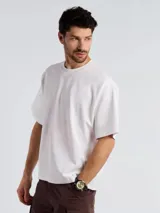 Camiseta de corte oversize color blanco, con cuello redondo y mangas cortas amplias.