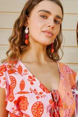 Aros colgantes compuestos por tres cuentas de resina en tonos rosa, fucsia y naranja, con cierre de gancho.