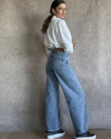 Pantalón de jean estilo wide leg con costuras verticales frontales, tiro alto y bolsillos laterales.