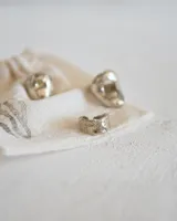 Anillo plateado con textura irregular y diseño rústico.